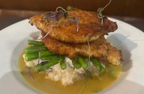 chicken cutlets served over vegetables and mashed potatoes