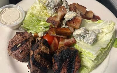 cuts of steak on a plate with wedges of lettuce