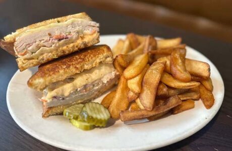 turkey sandwich on a plate with steak fries
